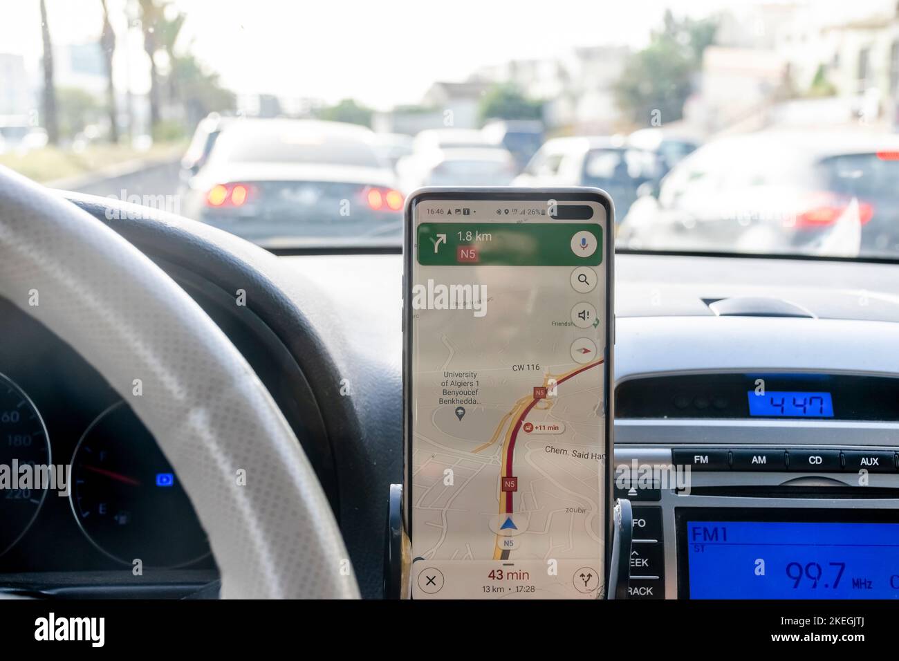 Algeri. Congestione del percorso nell'applicazione delle mappe, schermo dello smartphone dall'interno del cruscotto dell'auto e congestione del traffico all'esterno della vista dei freni dal parabrezza. Foto Stock