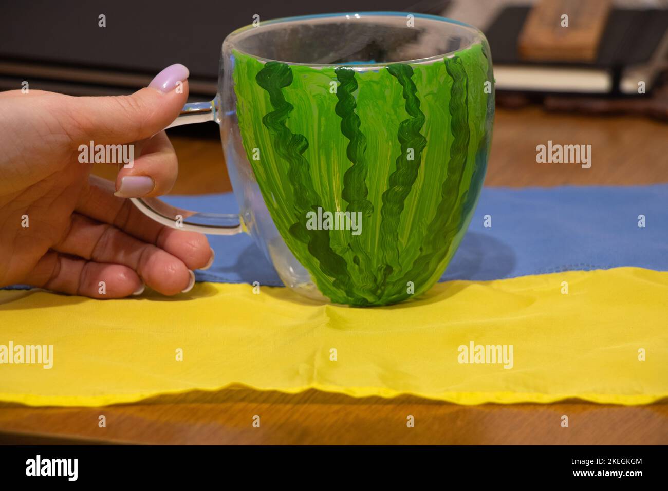 Una coppa con l'immagine di un anguria si trova sul tavolo sulla bandiera dell'Ucraina nell'appartamento, la liberazione di Kherson, la guerra in Ucraina Foto Stock