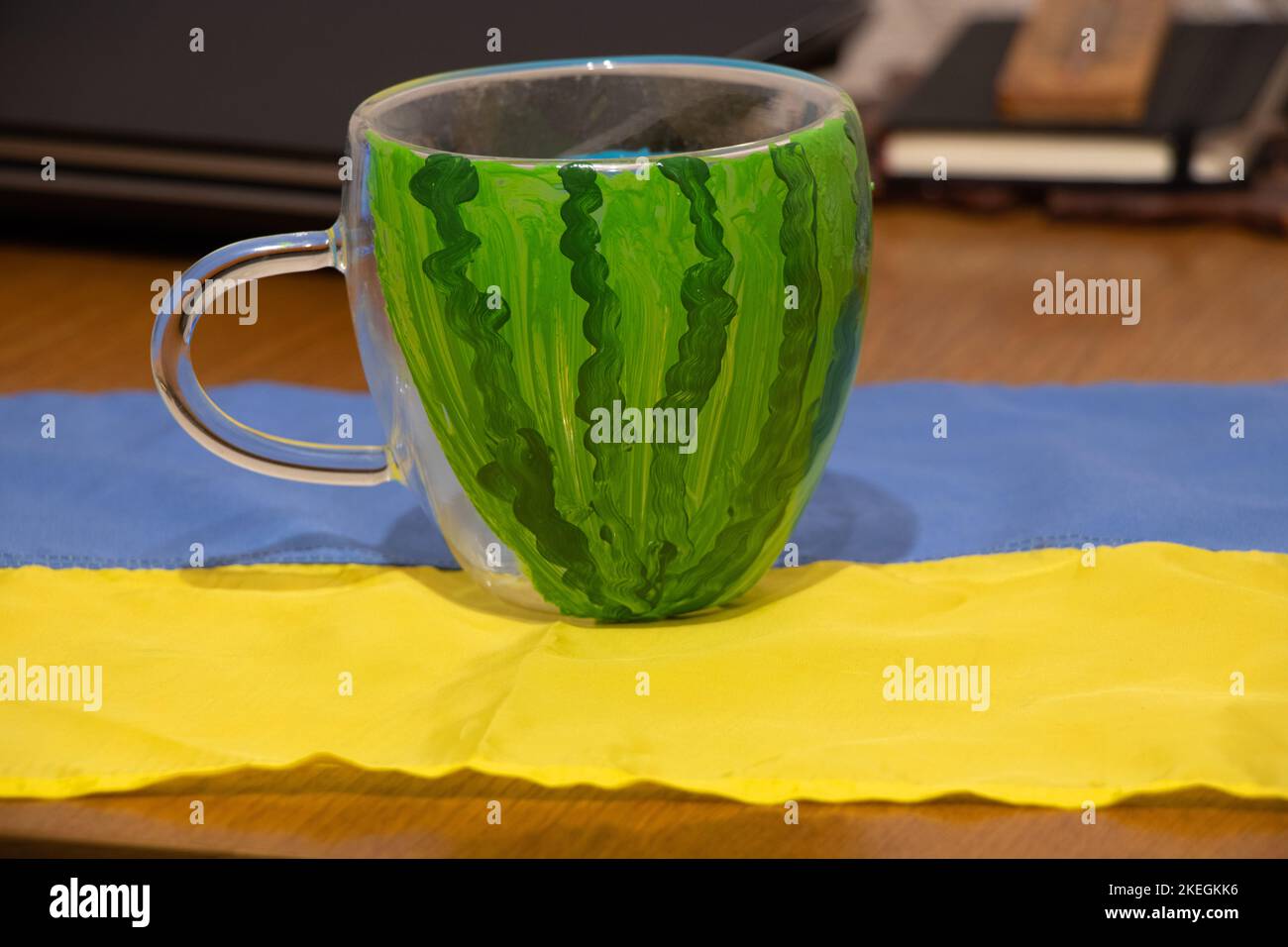 Una coppa con l'immagine di un anguria si trova sul tavolo sulla bandiera dell'Ucraina nell'appartamento, la liberazione di Kherson, la guerra in Ucraina Foto Stock