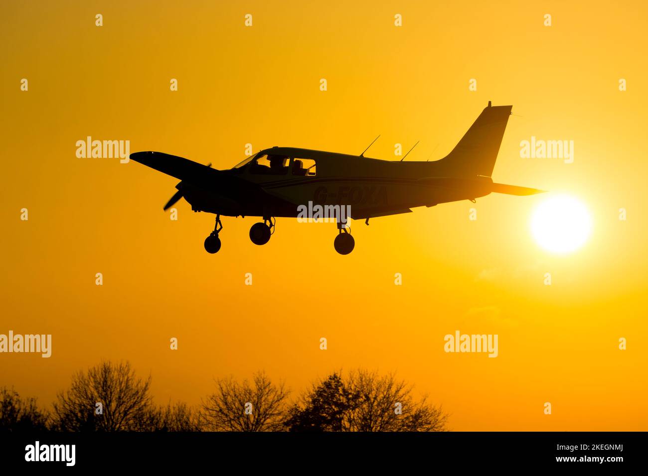 Piper PA-28-161 Cadet atterrando al tramonto, Wellesbourne Airfield, Warwickshire, Regno Unito (G-FOXA) Foto Stock