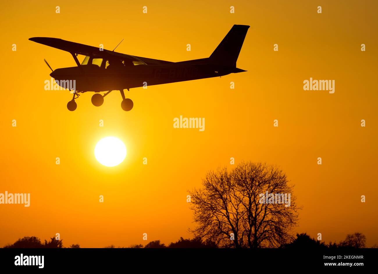 Cessna 152 atterrando al tramonto, Wellesbourne Airfield, Warwickshire, Regno Unito (G-BWNC) Foto Stock