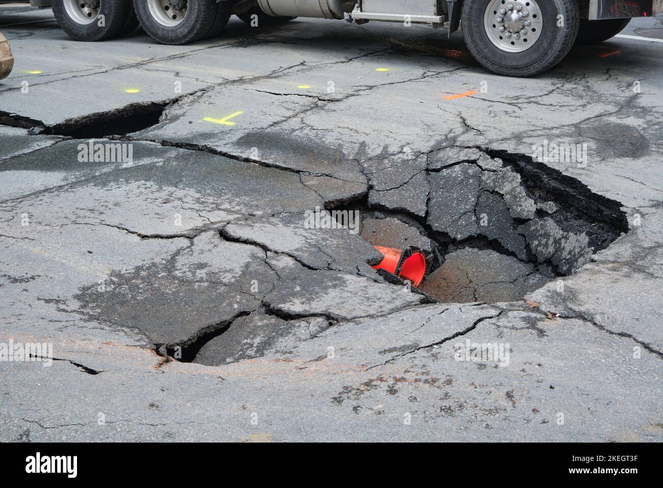 Buco di affondamento nel mezzo della strada asfaltata che segue il crollo della strada Foto Stock