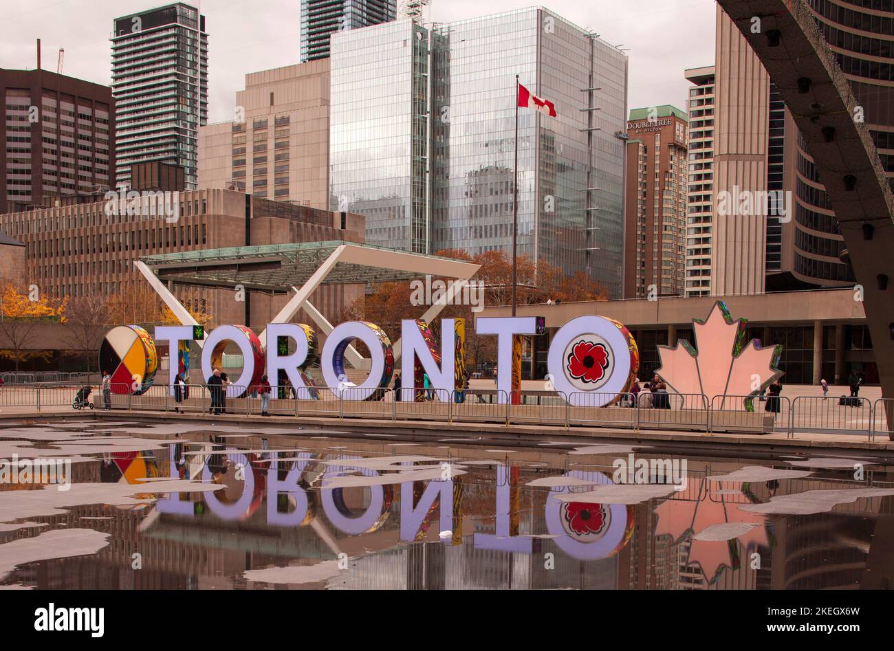 12 2022 novembre: Simbolo di Toronto decorato con papavero ricordo giorno che si riflette nelle pozzanghere autunnali a Piazza Nathan Phillips in centro Foto Stock