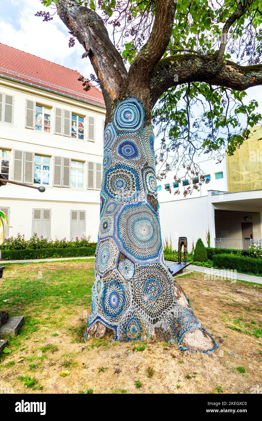 Tronco d'albero coperto di crochet al di fuori del Musée des Beaux-Arts, Mulhouse, Francia Foto Stock