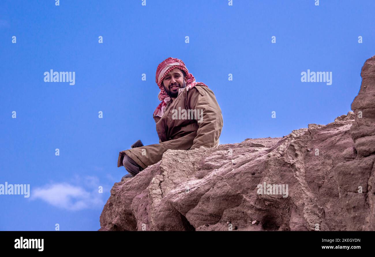 Pastore beduino seduto sulla roccia Wadi Dana Giordania Foto Stock