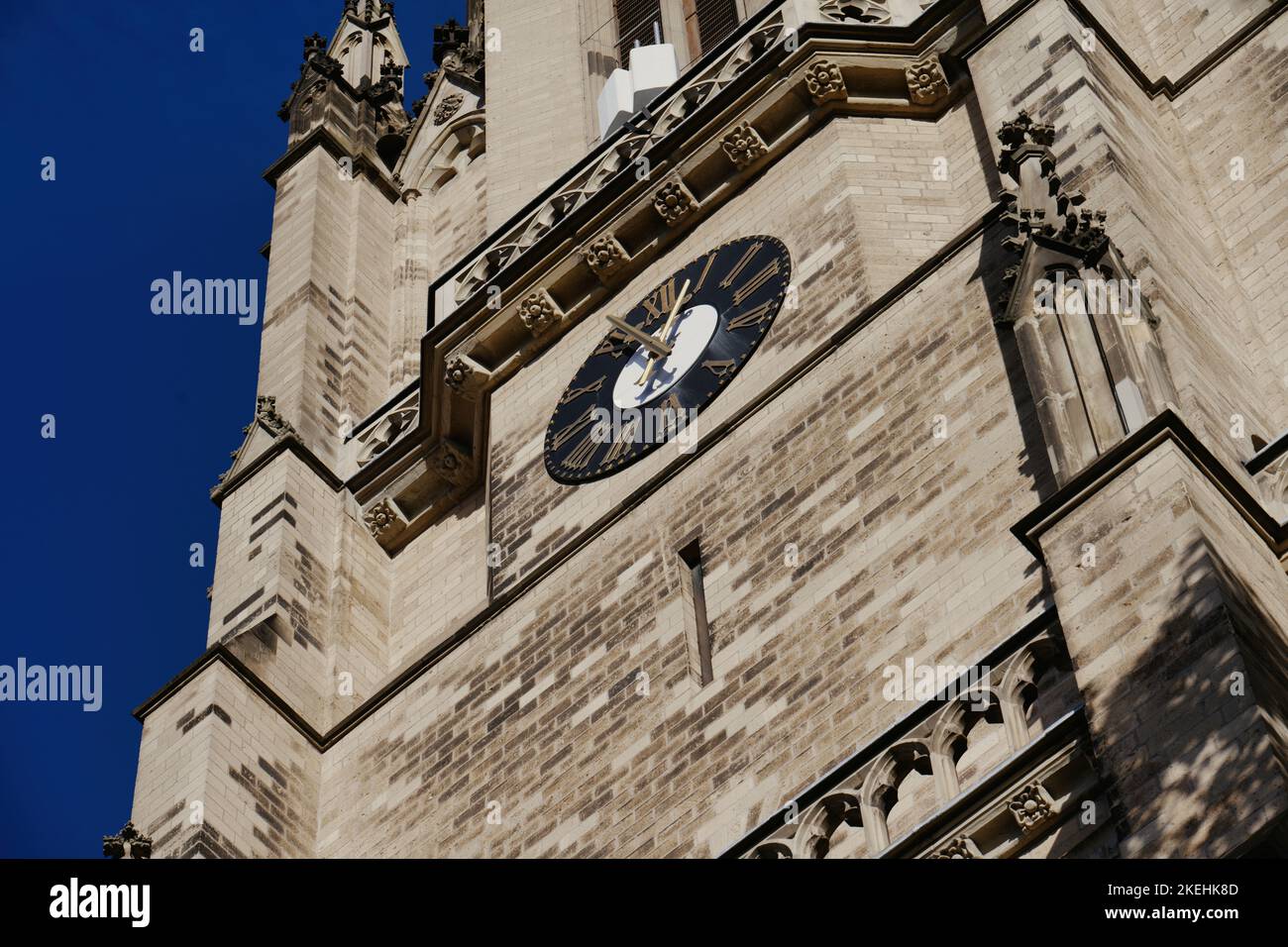 torre orologio di una chiesa storica di colonia di fronte a un cielo blu profondo Foto Stock