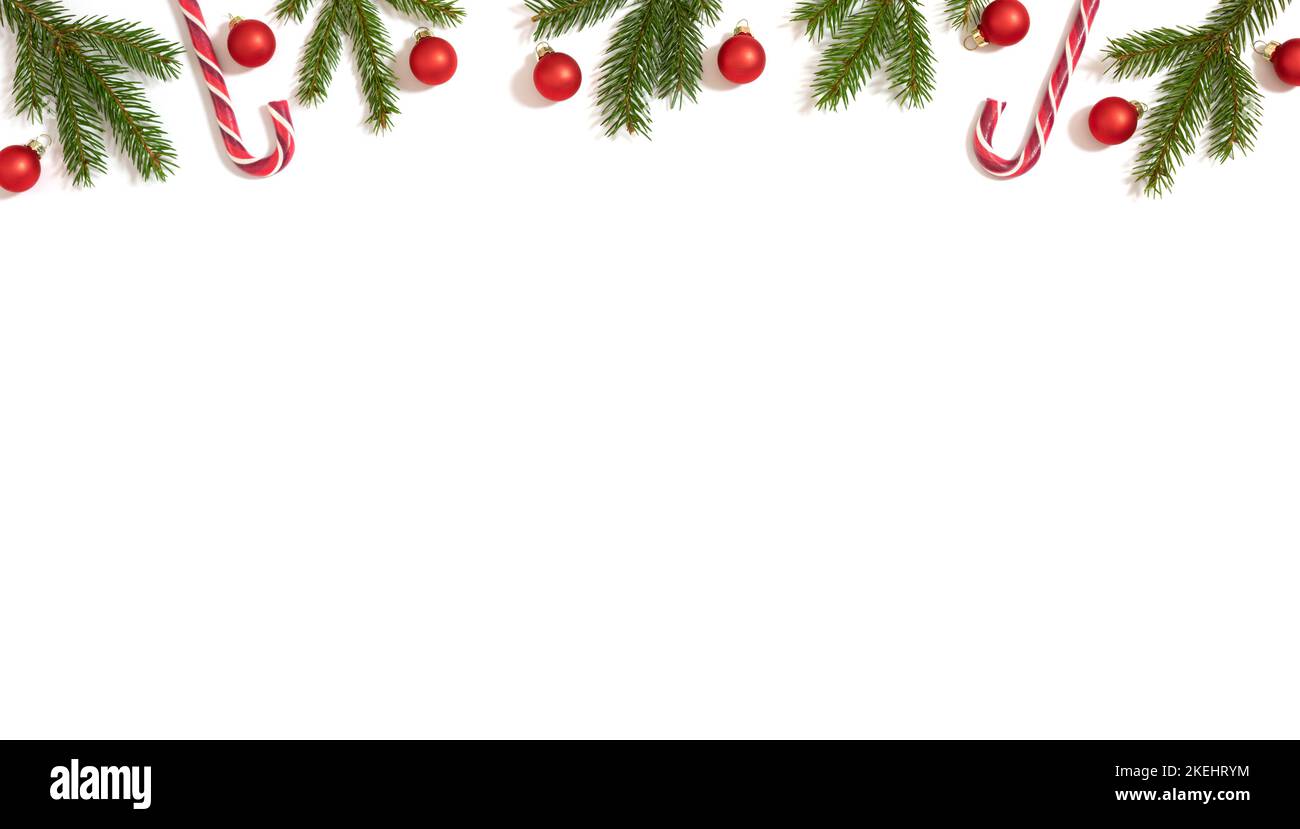 Natale bordo con rami di abete, canna da zucchero e baubles rosso isolato su uno sfondo bianco. Banner. Cornice del nuovo anno. Spazio di copia, modello. Vista dall'alto, Foto Stock