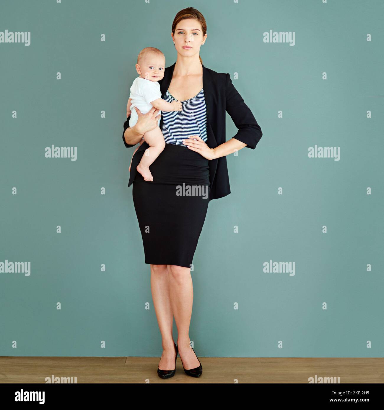 La maternità e la mia carriera sono altrettanto importanti per me. Studio shot di una giovane donna d'affari di successo che porta il suo adorabile bambino ragazzo. Foto Stock