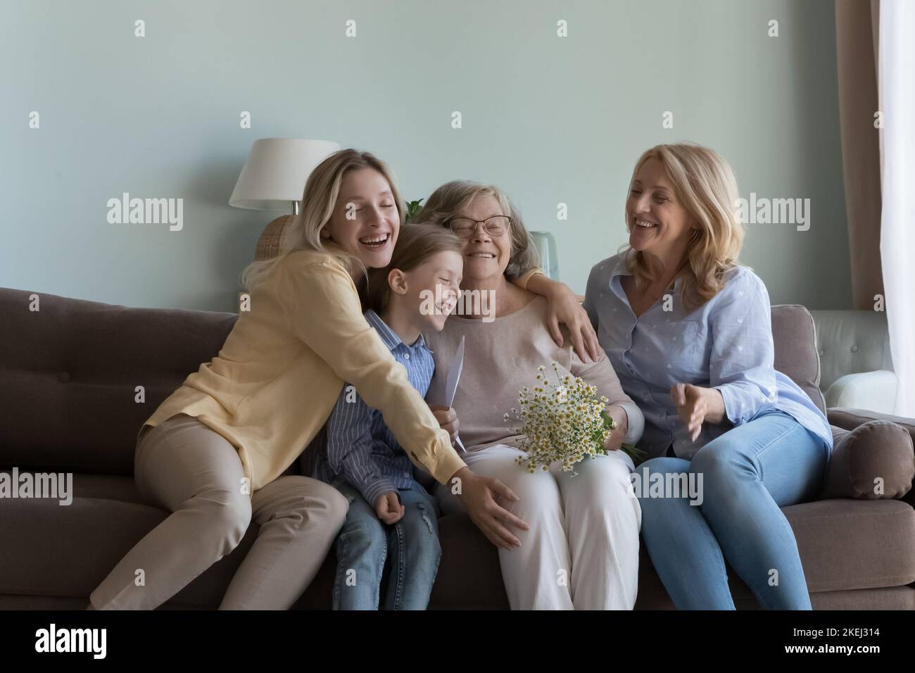 Famiglia amorevole multi generazionale che si congratula con la nonna con l'evento di vita Foto Stock