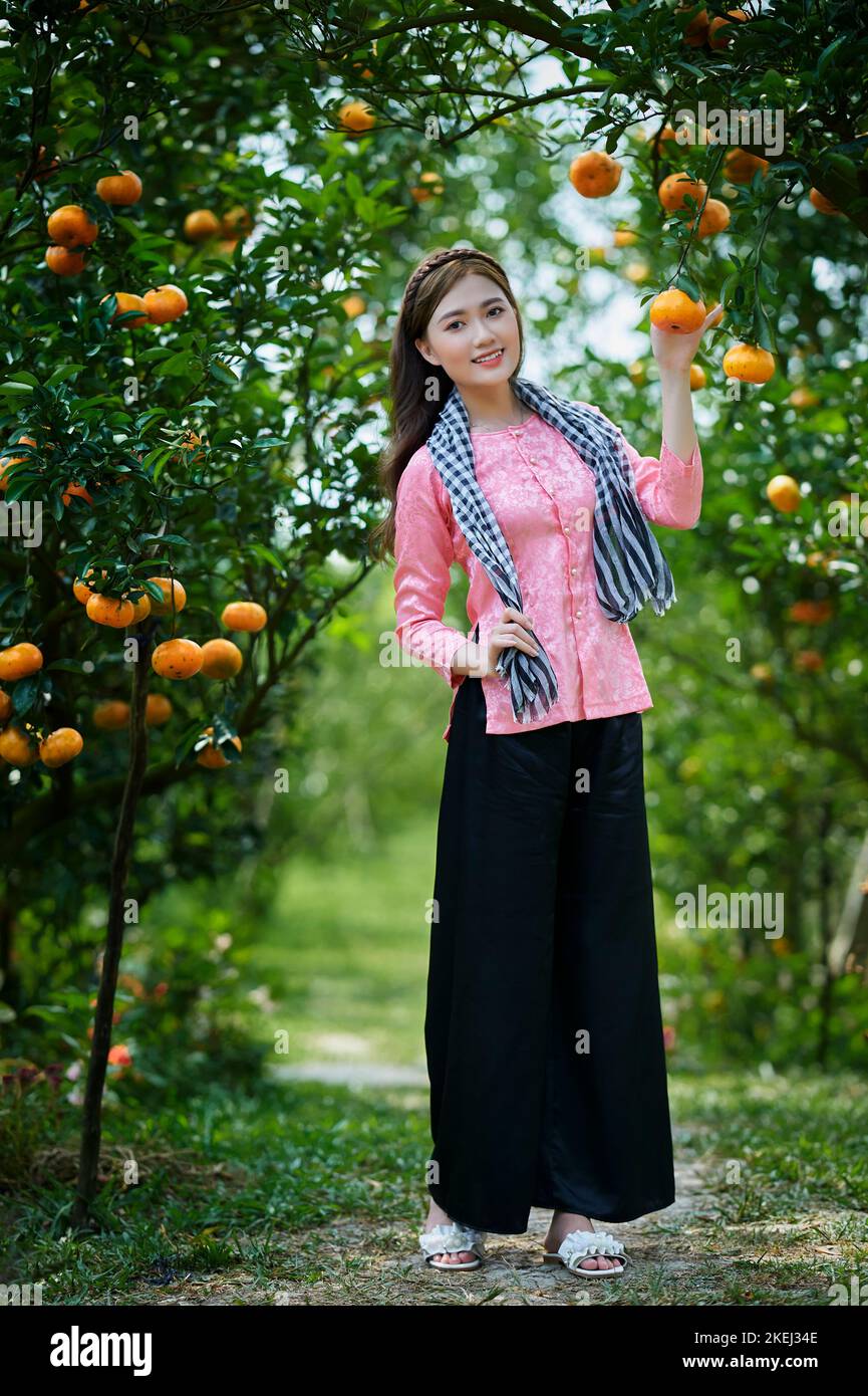 SA Dic City, Vietnam: Ritratto Western girl in giardino maturo tangerino Foto Stock