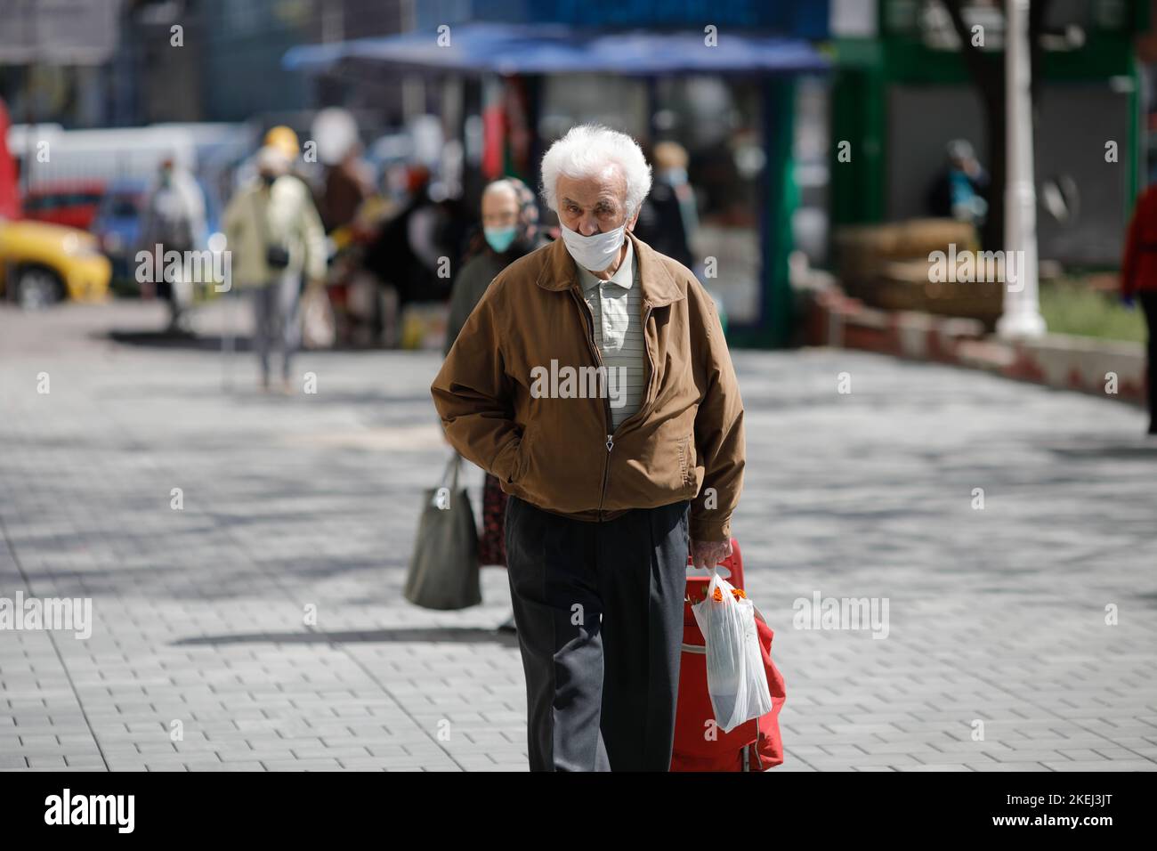 Bucarest, Romania - 16 aprile 2020: Gli anziani che indossano maschere protettive fanno il loro shopping in un mercato aperto occupato a Bucarest durante l'epidemia di covid-19 Foto Stock