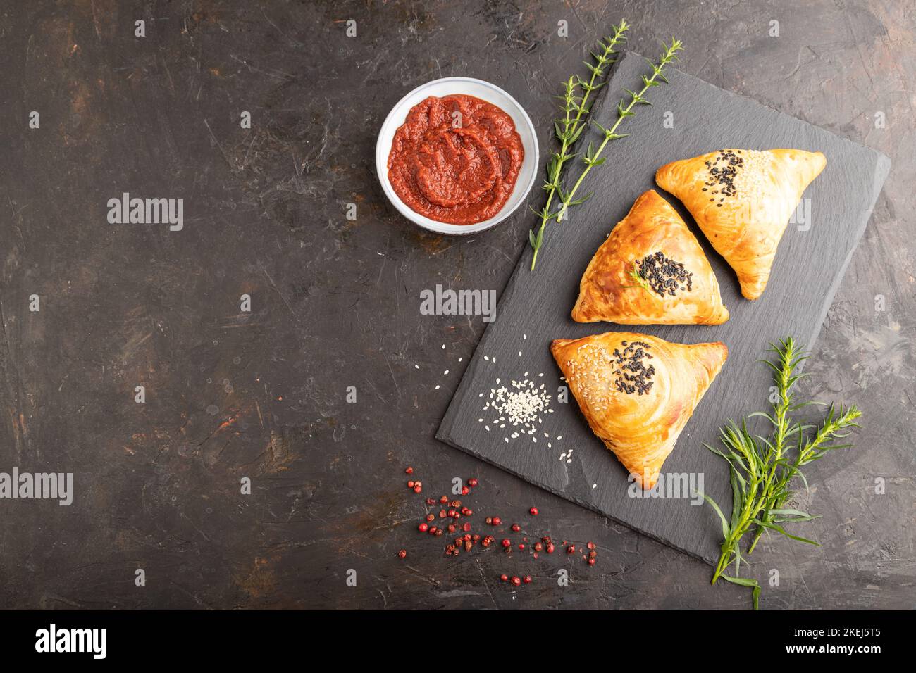 Pasticceria asiatica fatta in casa samosa su fondo in cemento nero. Vista dall'alto, piano, spazio copia. Foto Stock