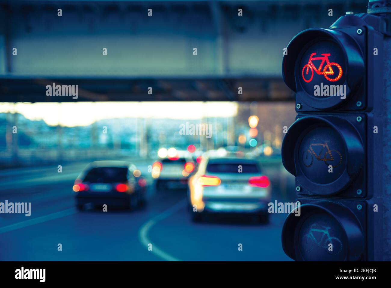 Il semaforo delle biciclette contro le auto sfocate in città Foto Stock