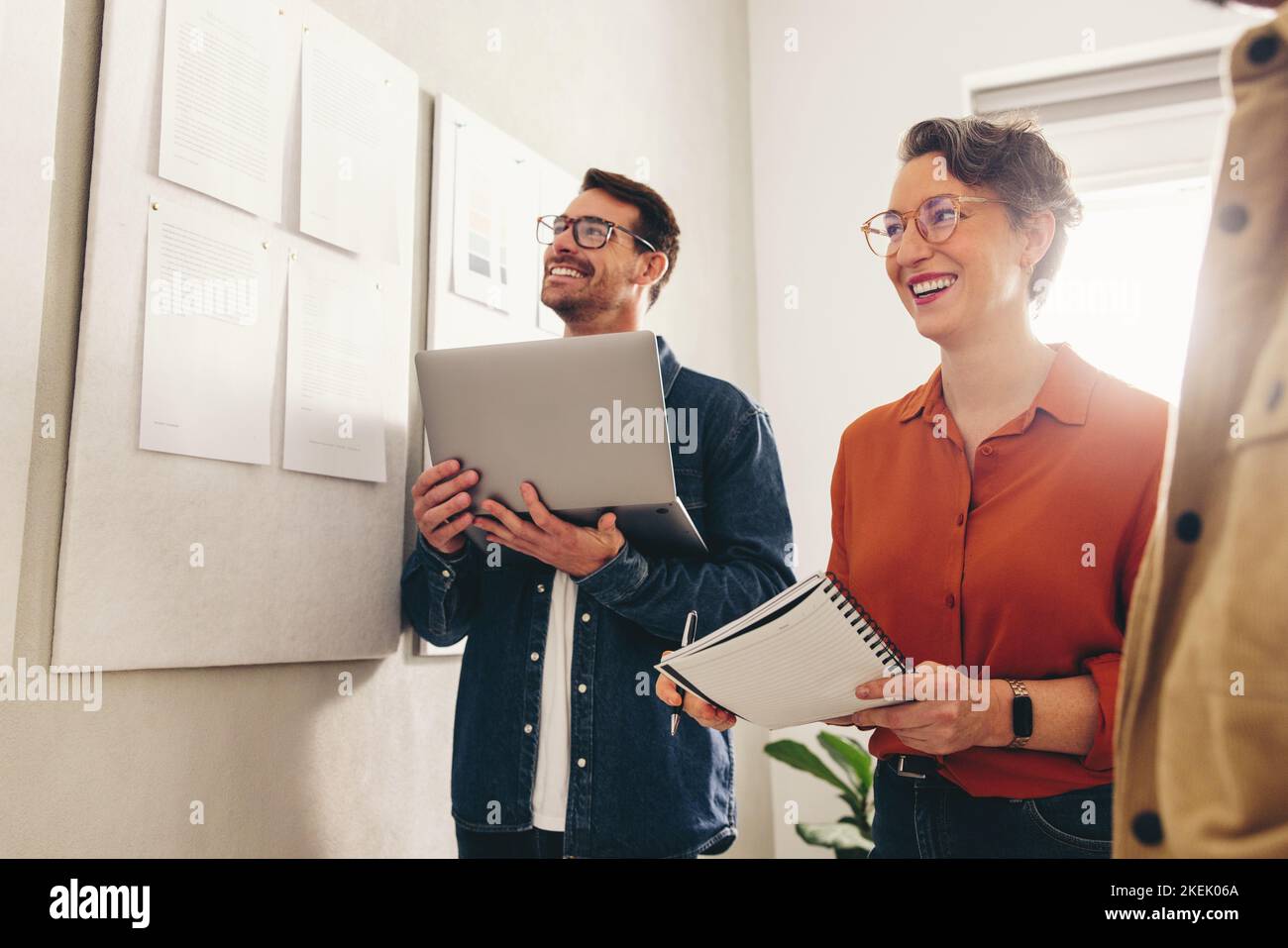 Allegro businesspeople sorridente felice mentre ha una riunione in un posto di lavoro creativo. Gruppo di colleghi aziendali che analizzano alcuni report di marketing Foto Stock