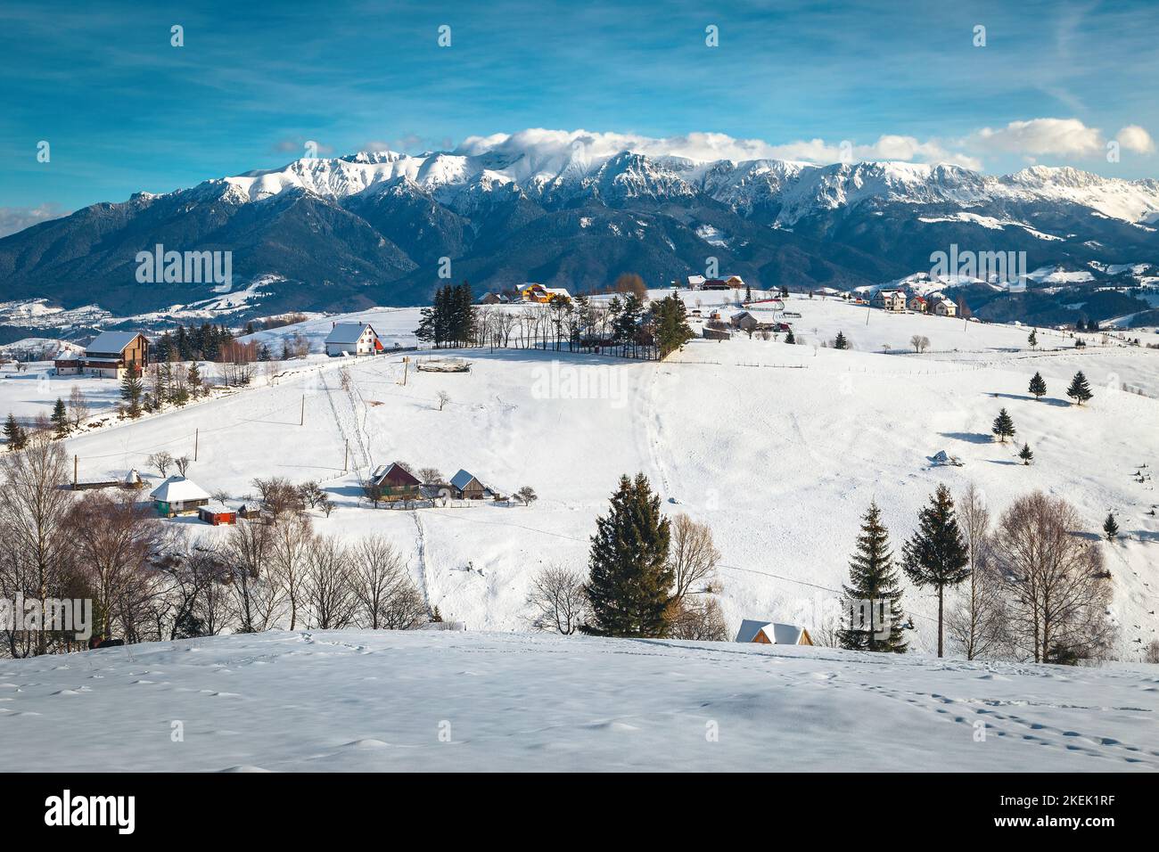 Splendido villaggio alpino e fantastico scenario invernale con montagne innevate sullo sfondo, villaggio di Pestera, Romania, Europa Foto Stock