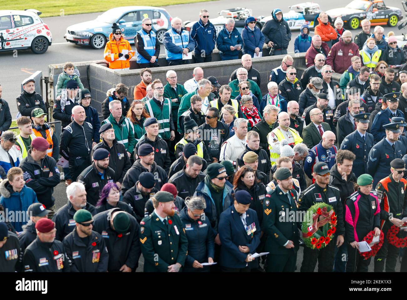 Anglesey, Galles, Regno Unito, 13 Nov 2022. Servizio di remembrance in pit lane sul circuito Anglesey (Trac Mon). 12 ore di endurance gara motoristica ferma in griglia per ricordare il servizio domenica Red Water Images / Alamy Live News Foto Stock