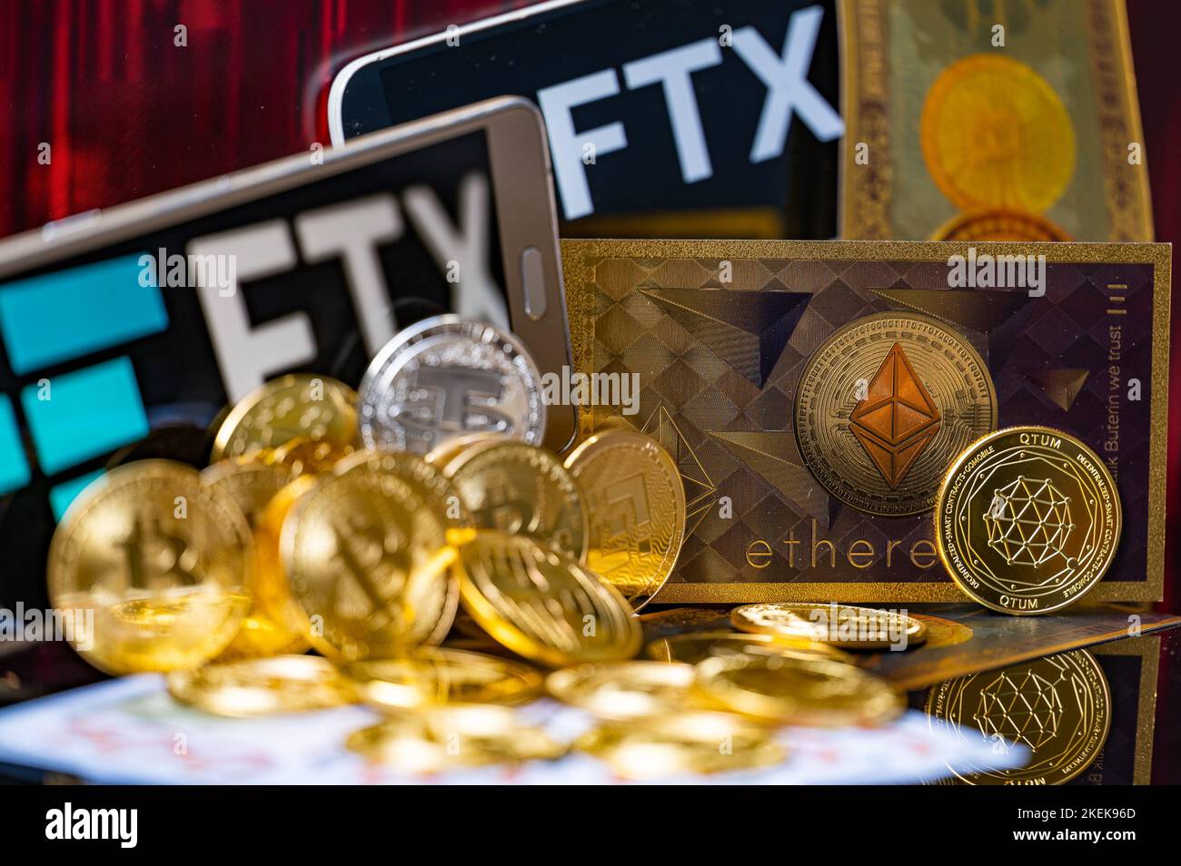 A titolo illustrativo, vengono visualizzati il logo FTX con le monete criptate con la banconota da 100 dollari. FTX ha difficoltà a far fronte a un'ondata di ritiri dei clienti. Foto Stock
