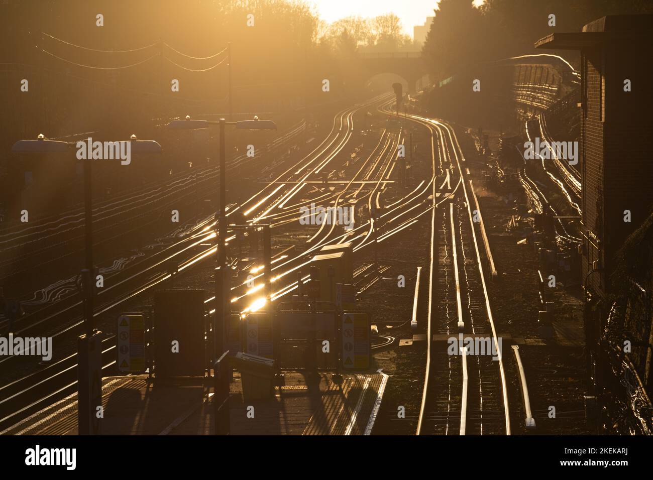 Una vista spettacolare delle rotaie dorate della metropolitana di londra al mattino presto. Guardando al sole non ci sono treni sulle linee. Potrebbe essere una giornata di sciopero Foto Stock