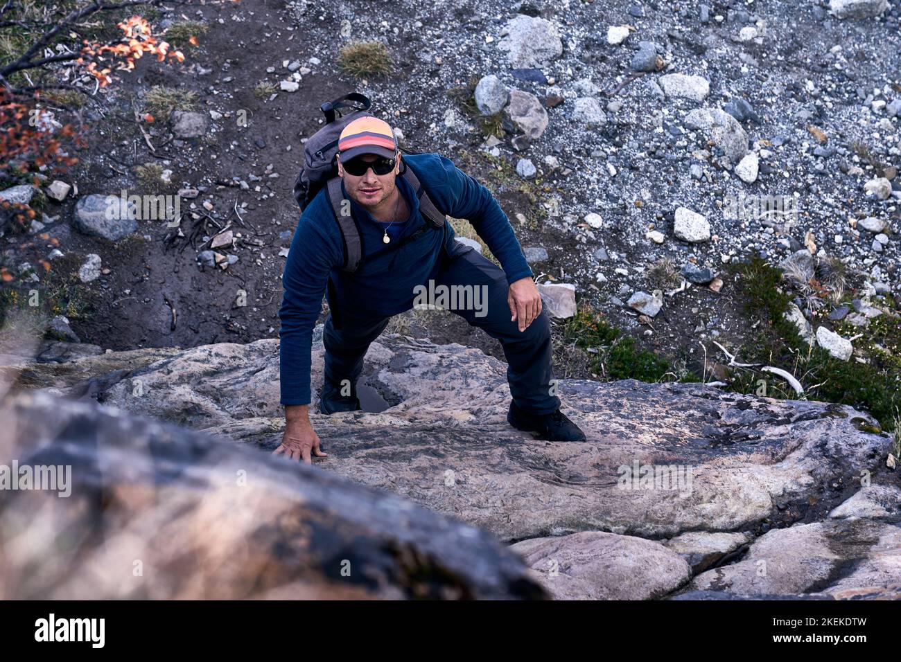 Uomo bianco di 40 anni che si arrampica su una roccia su un sentiero di trekking a El Chalten, provincia di Santa Cruz, Repubblica Argentina Foto Stock