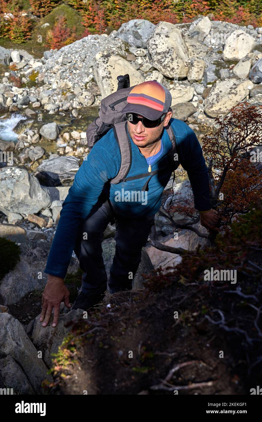 Uomo bianco di 40 anni che si arrampica su una roccia su un sentiero di trekking a El Chalten, provincia di Santa Cruz, Repubblica Argentina Foto Stock