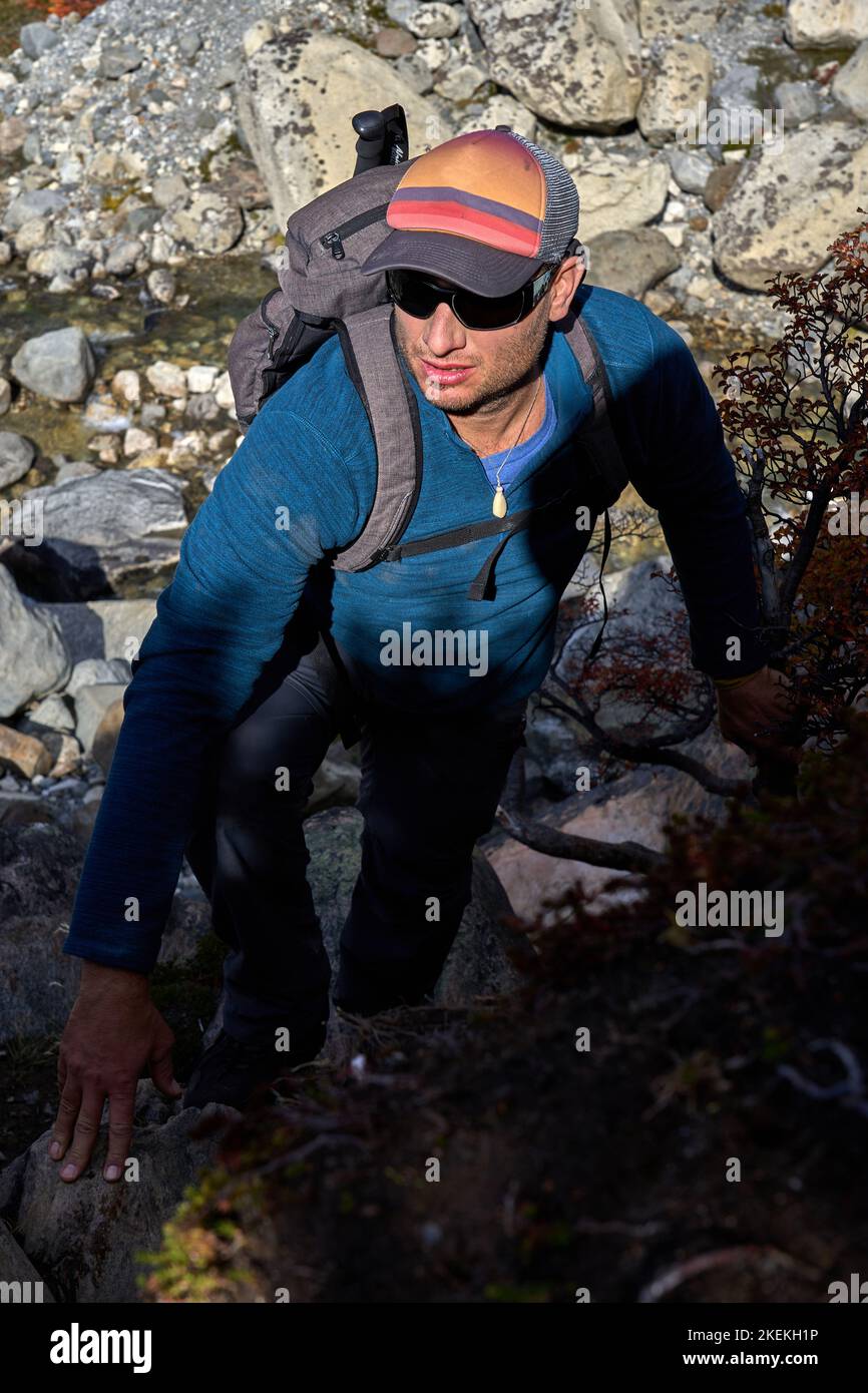 Uomo bianco di 40 anni che si arrampica su una roccia su un sentiero di trekking a El Chalten, provincia di Santa Cruz, Repubblica Argentina Foto Stock