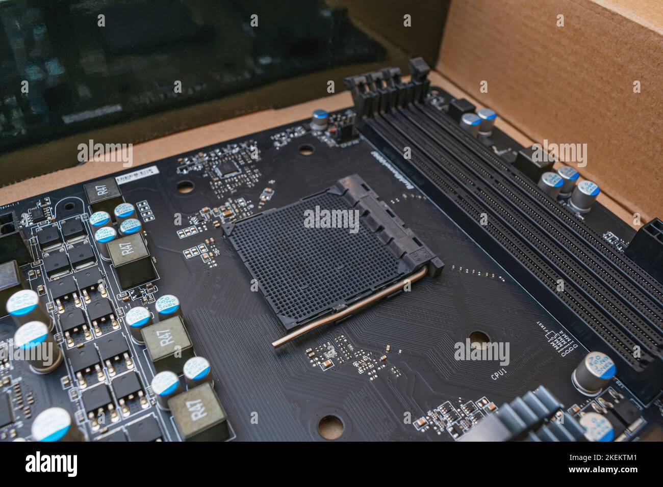 La scheda madre nera del computer si trova in una scatola dopo la riparazione Foto Stock