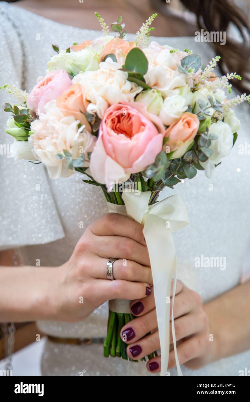 Mani di lo sposo e la sposa su un mazzo di nozze Foto Stock