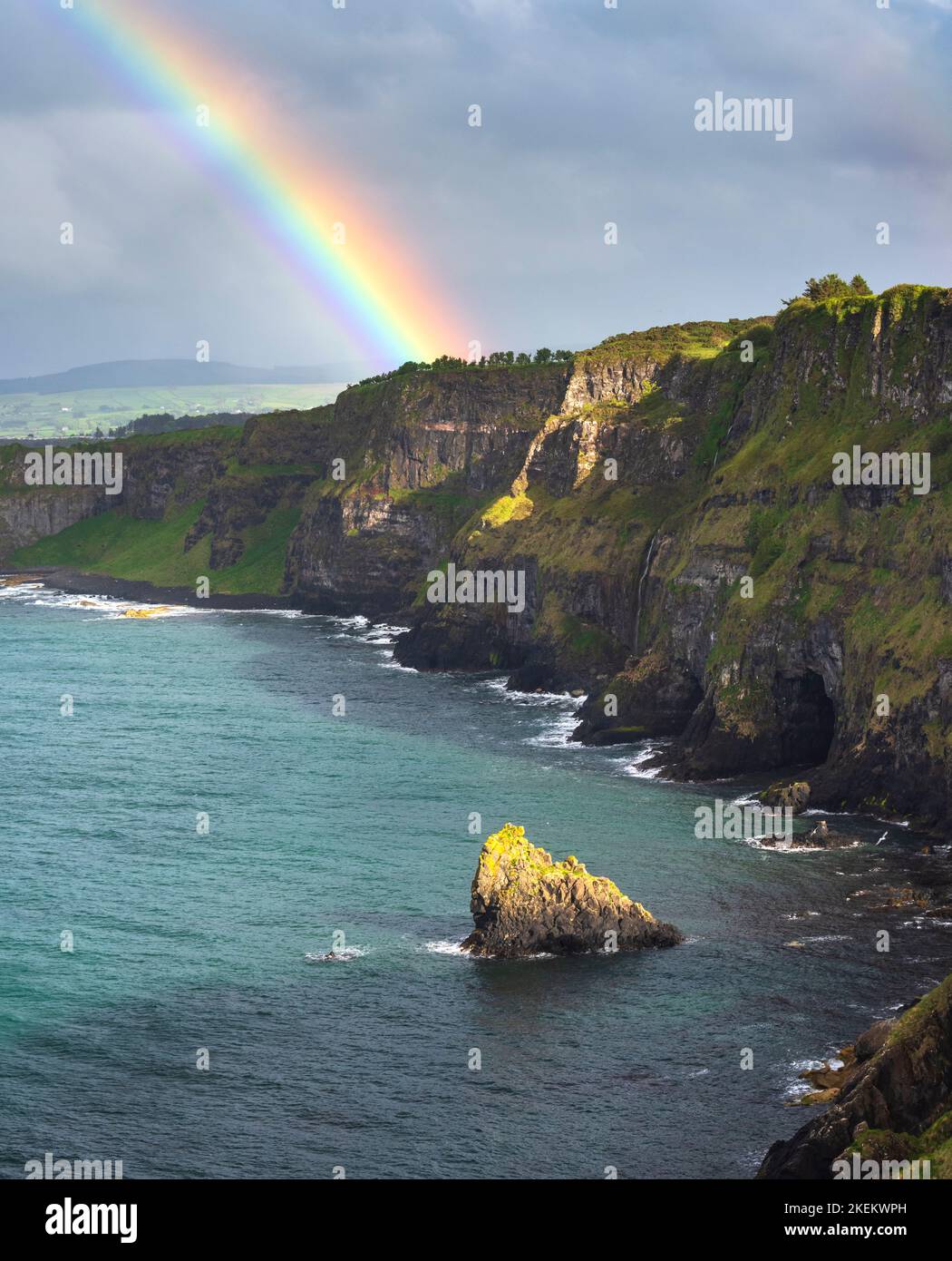 Arcobaleno catturato sulla costa di Antrim, il castello di Kinbane, Irlanda del Nord Foto Stock