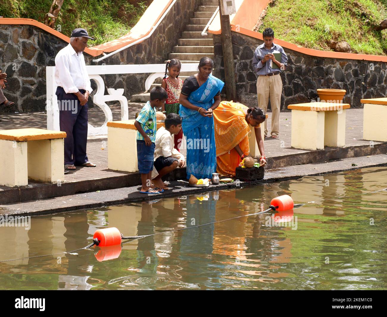 GRAND BASSIN, MAURITIUS - 24 FEBBRAIO 2011: La famiglia offre il cibo come culto rituale per il loro dio Shiva durante il festival indù di Maha Shivarat Foto Stock