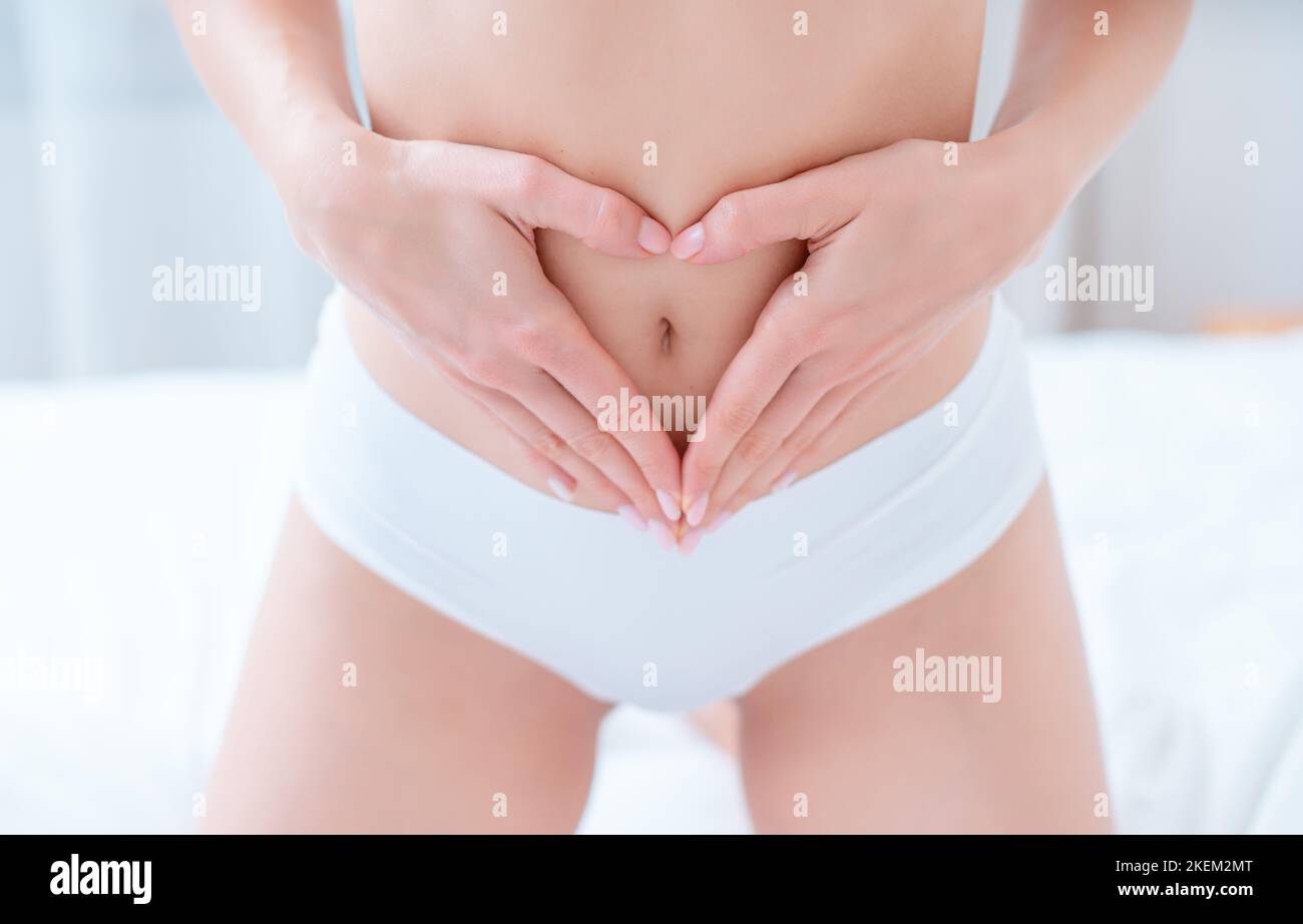 Donna con un intestino sano che mostra segno cardiaco Foto Stock