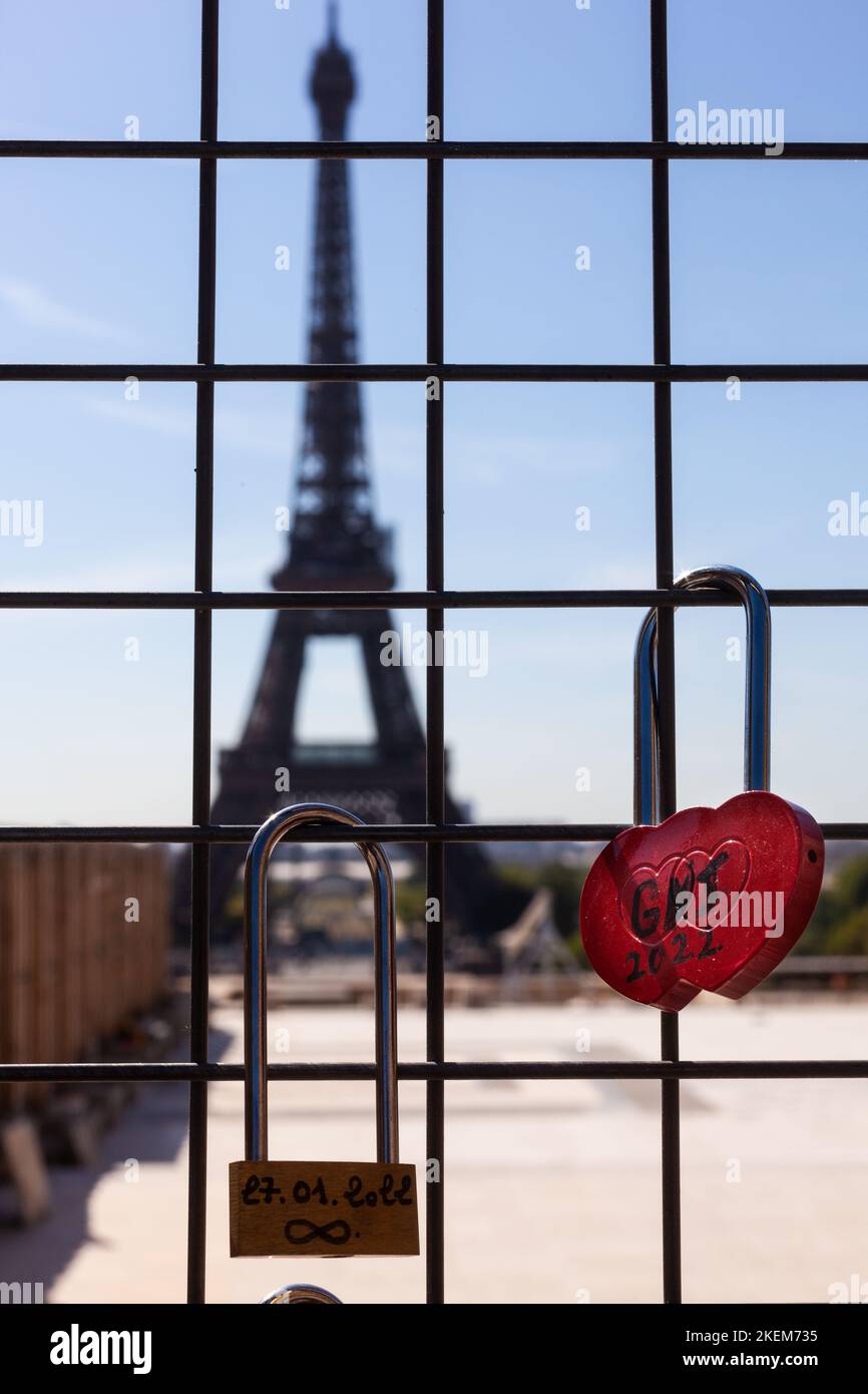 Lucchetto rosso sulla griglia di ferro, con due nomi di amanti e Torre Eiffel sullo sfondo, Parigi Foto Stock