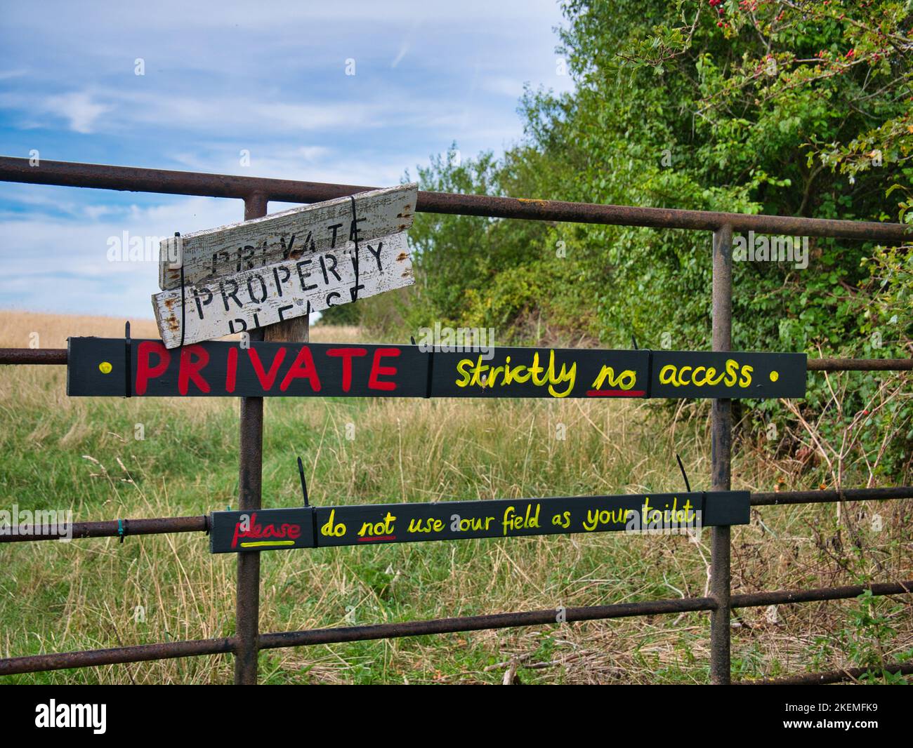 I cartelli fissati su un cancello accanto al North Norfolk Coast Path dicono agli escursionisti che la terra è privata e non deve essere utilizzata come toilette. Foto Stock