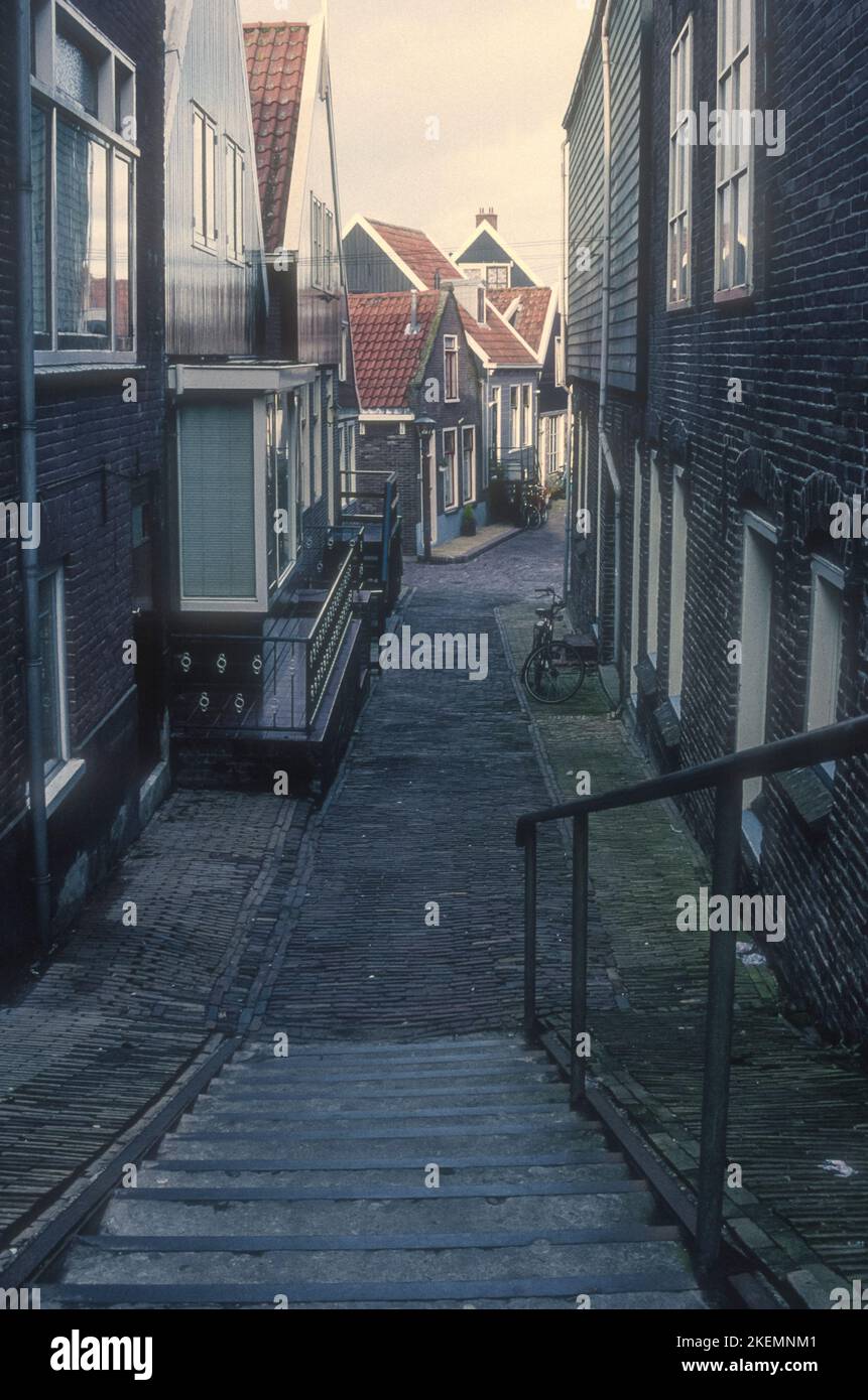 Archivio 1990s Fotografia dei gradini che scendono verso una strada laterale dal muro del porto di Volendam, Paesi Bassi. Foto Stock
