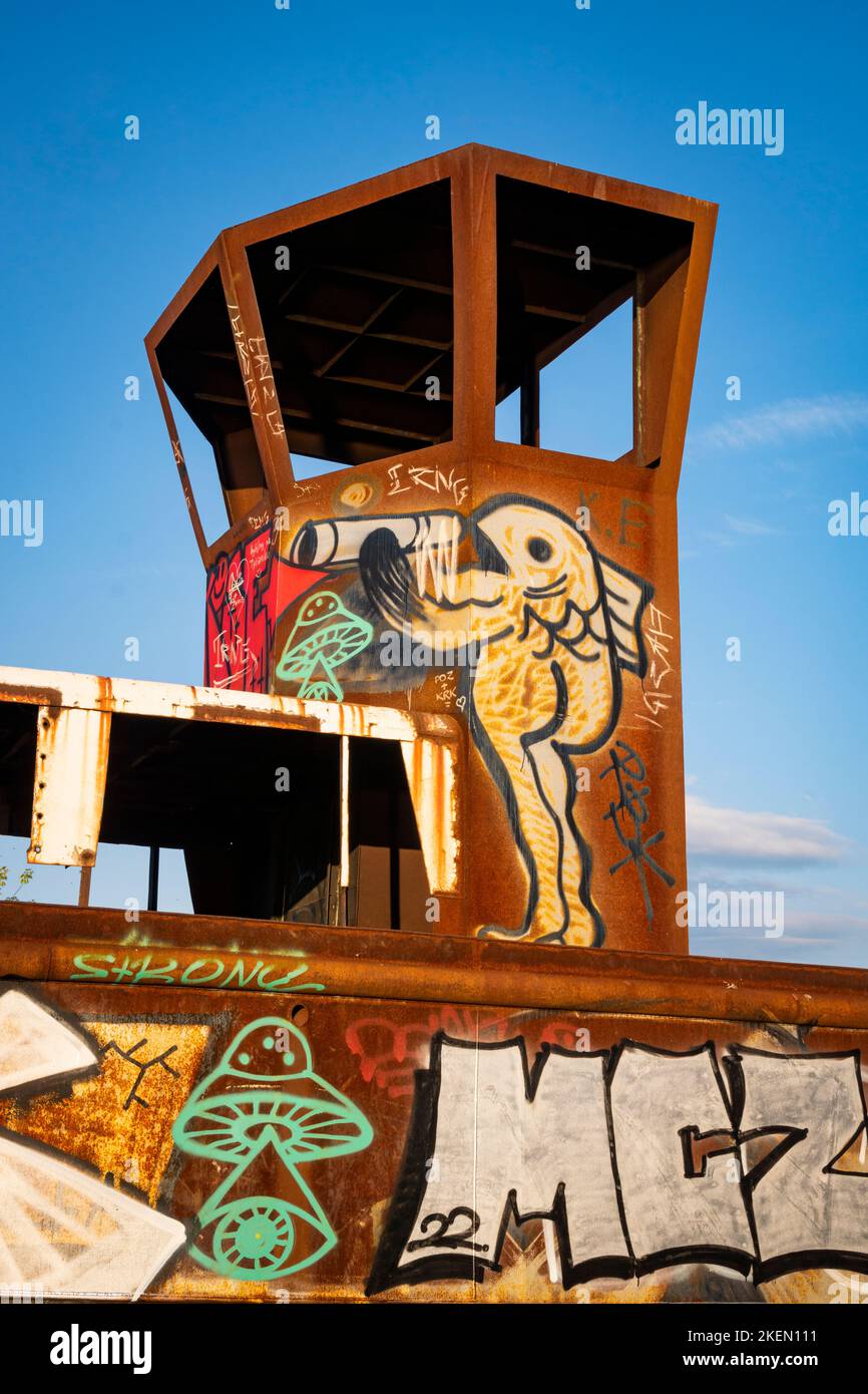 Graffiti: Un pesce bevente dipinto sul relitto di una vecchia nave arrugginita. Cracovia, Polonia, Europa. Foto Stock