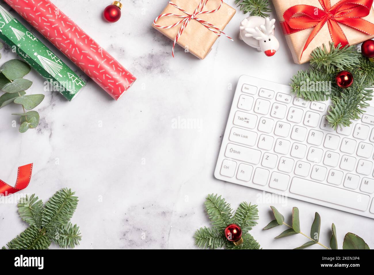 Spazio di lavoro per Natale e Capodanno con tastiera, confezione regalo e albero di natale, vista dall'alto piatta con spazio per fotocopie. Foto Stock
