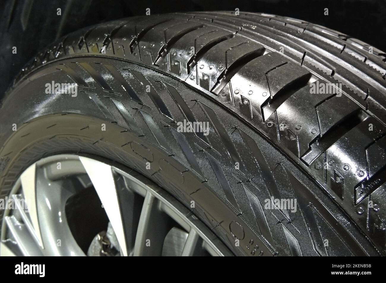 Vista dall'alto del pneumatico per auto lucidato sul pavimento in cemento del garage Foto Stock