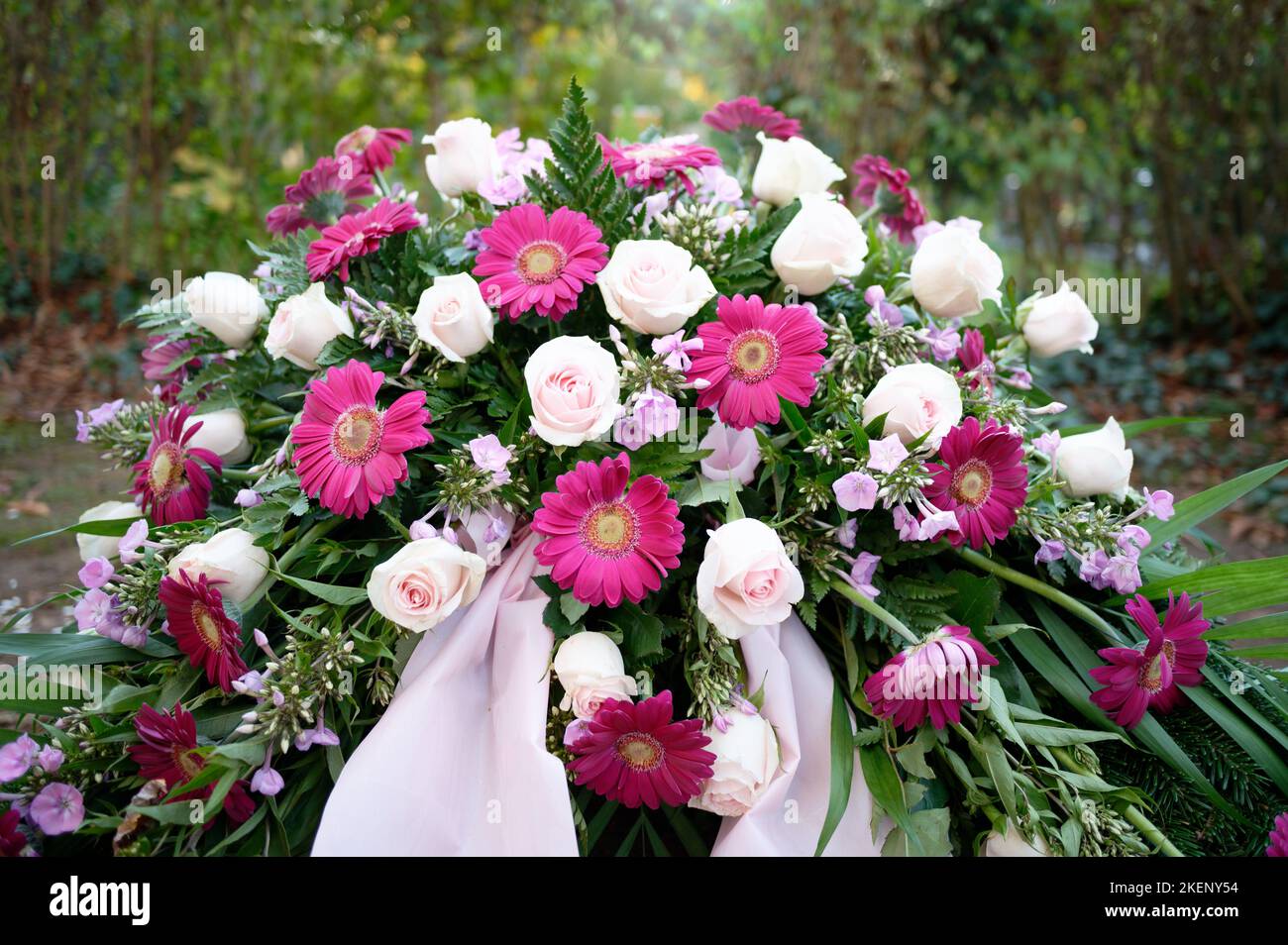 rose viola e rosa e gerbera come fiori funerari su una tomba Foto Stock