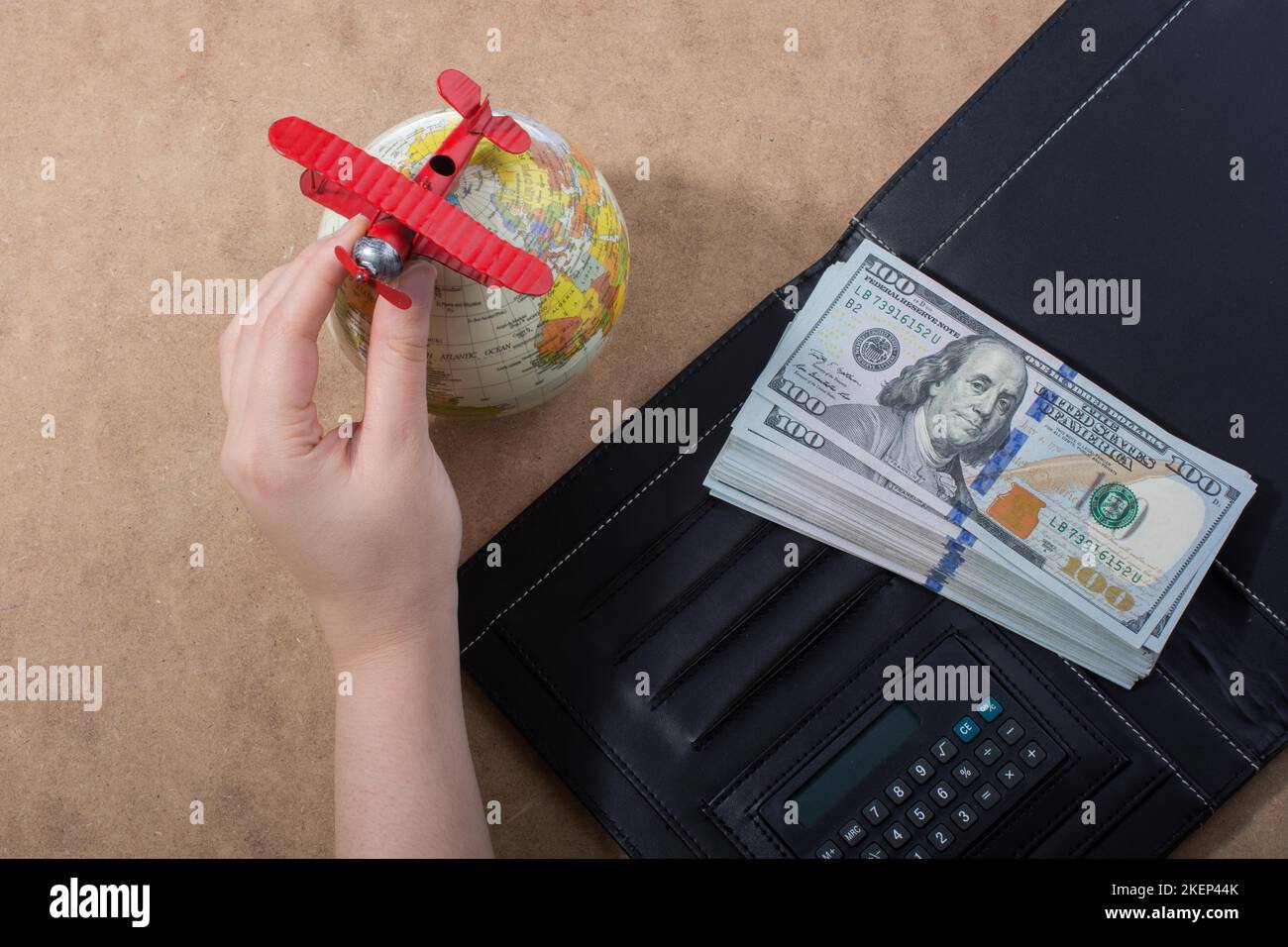 Mano che tiene le banconote del dollaro americano isolate su fondo di legno Foto Stock