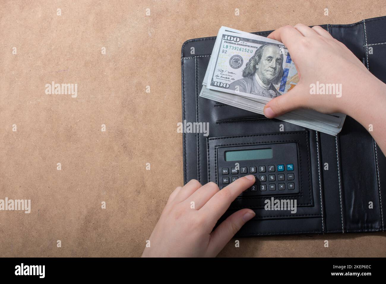 Mano che tiene le banconote del dollaro americano isolate su fondo di legno Foto Stock