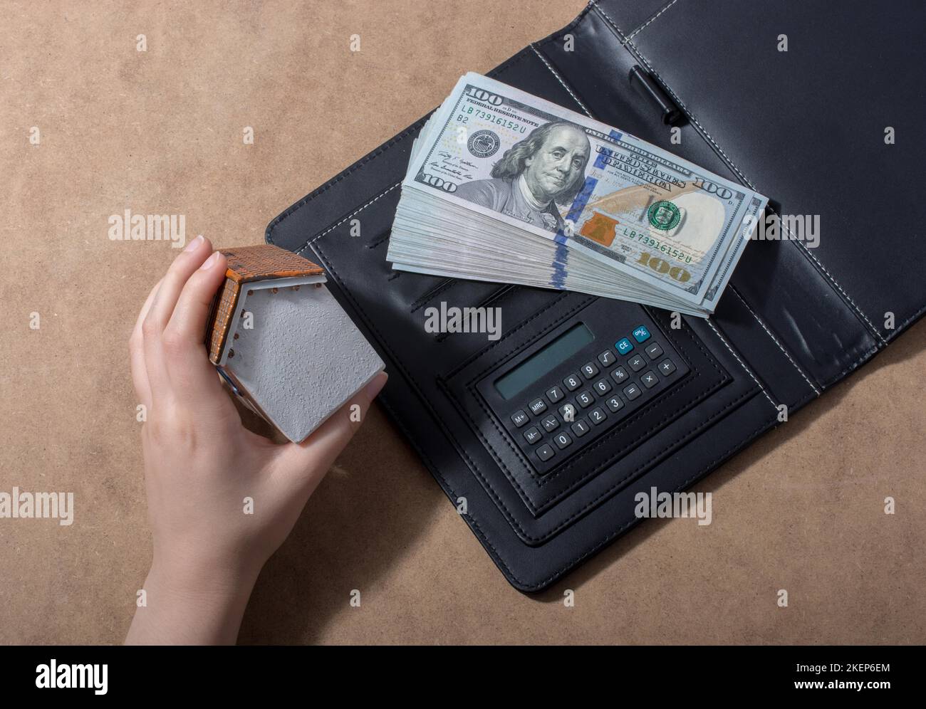 Mano che tiene le banconote del dollaro americano isolate su fondo di legno Foto Stock