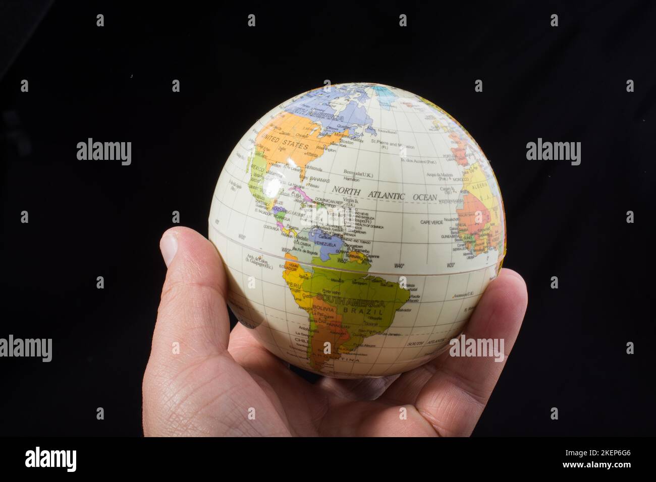 Mano che tiene un globo con la mappa su di esso Foto Stock