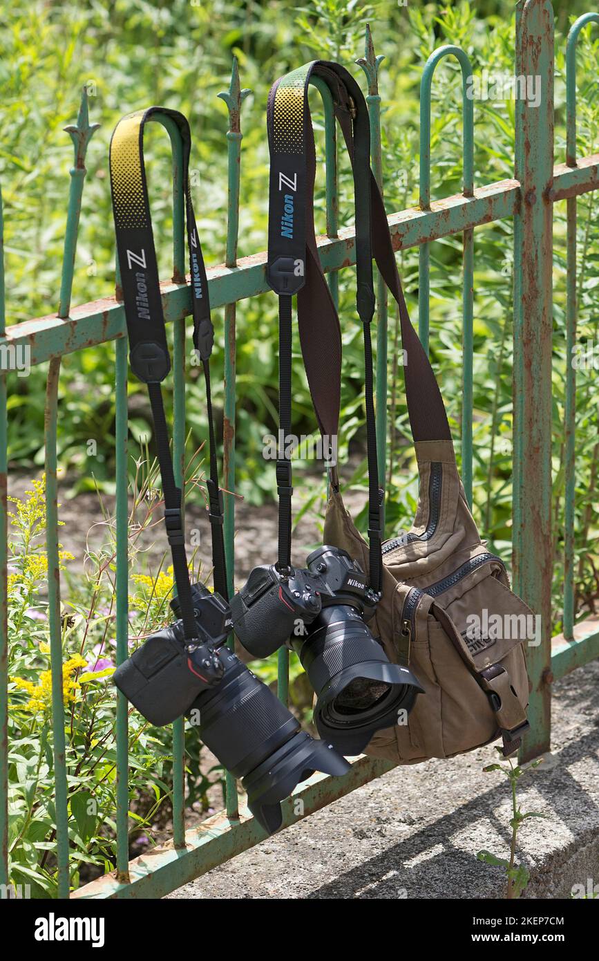 Fotocamere e borsa fotografica appesa a una recinzione da giardino, Baviera, Germania Foto Stock