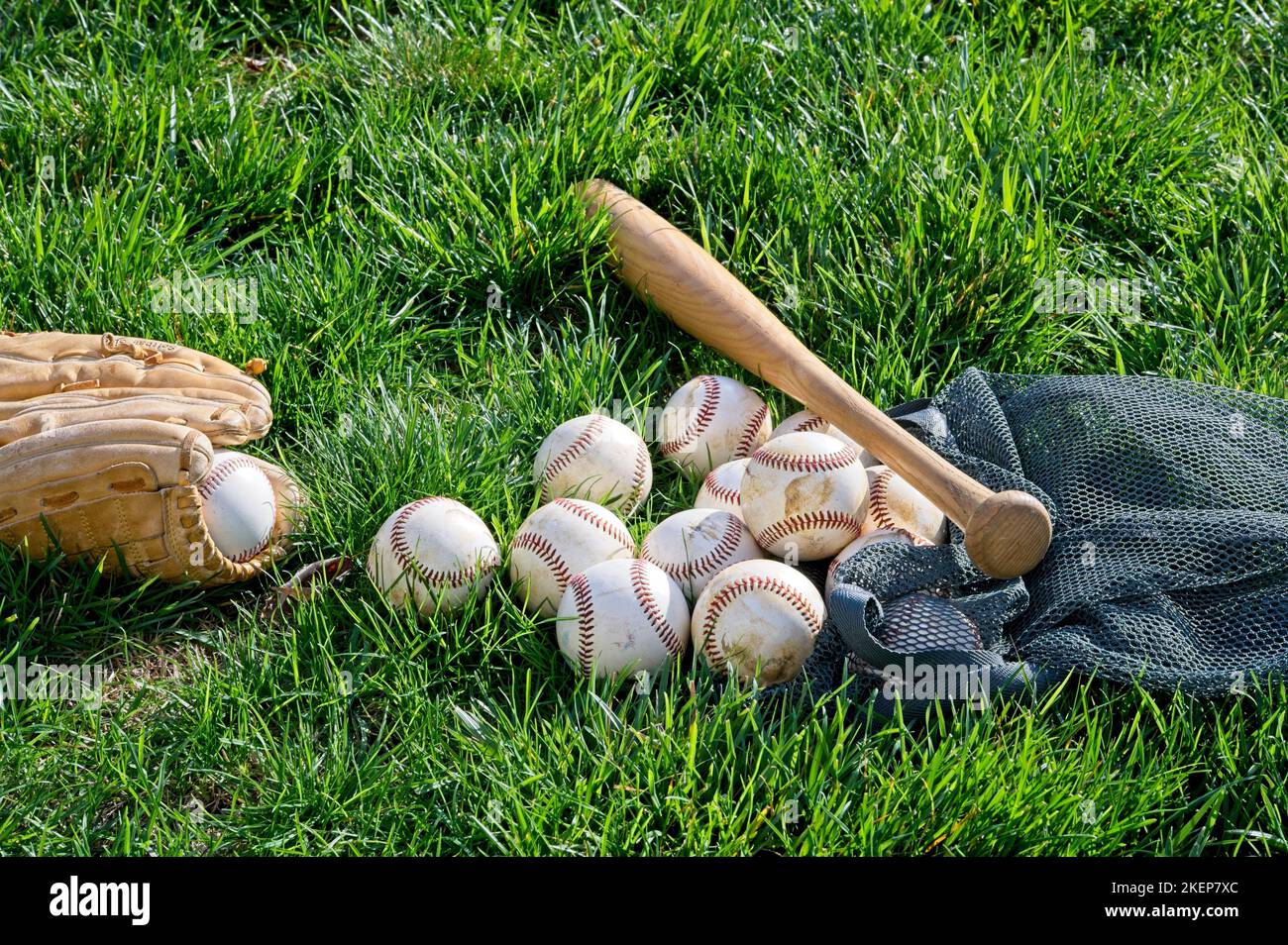 Palle di baseballs marrone guanto e un pipistrello in erba Foto Stock