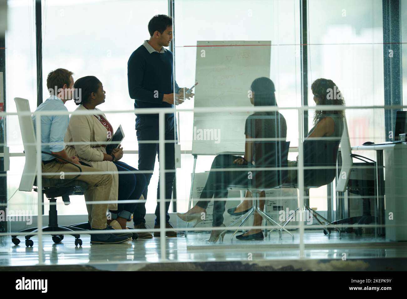 Un gruppo di colleghi che si occupa del brainstorming in un ufficio. Foto Stock