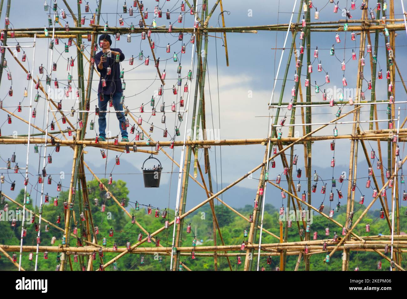 Uomo asiatico al lavoro su impalcatura di bambù preparazione per Nakhon Phanom festa in barca, Thailandia. Foto Stock