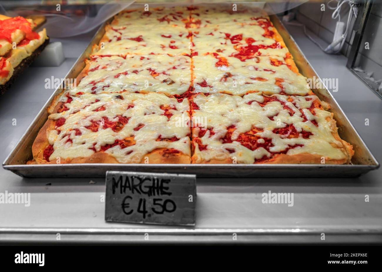Pizza Margherita appena fatta a fette in una padella in mostra presso un ristorante nel centro storico di Manarola, nelle cinque Terre, sul Mar Mediterraneo Foto Stock