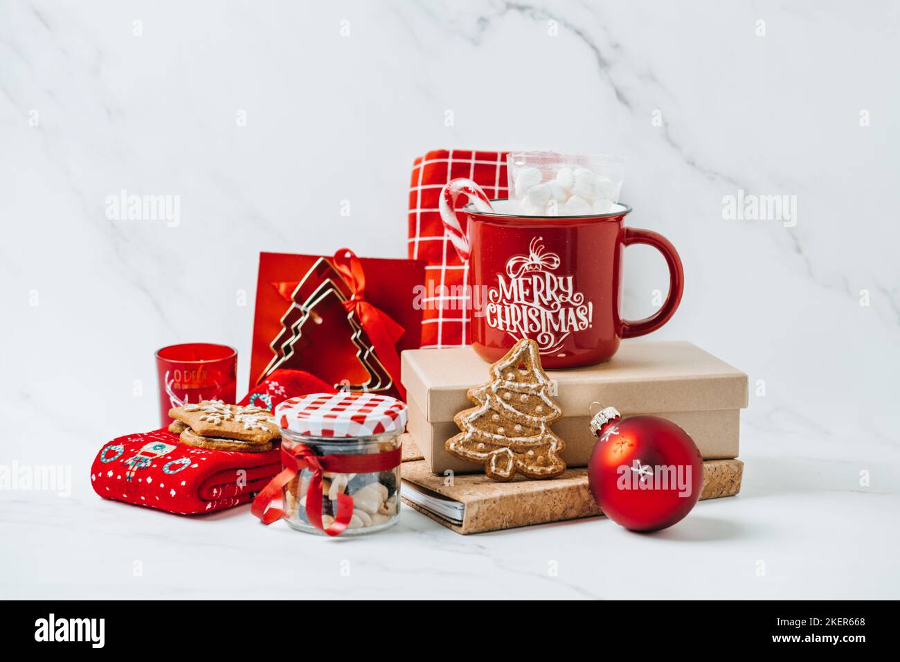 Regali di natale sostenibili, idee regalo di Natale per le vacanze ecocompatibili. Tazza senza scarti rossa e marrone, borsa per acquisti, calzini, blocco note, dolci, biscotti sul tavolo Foto Stock