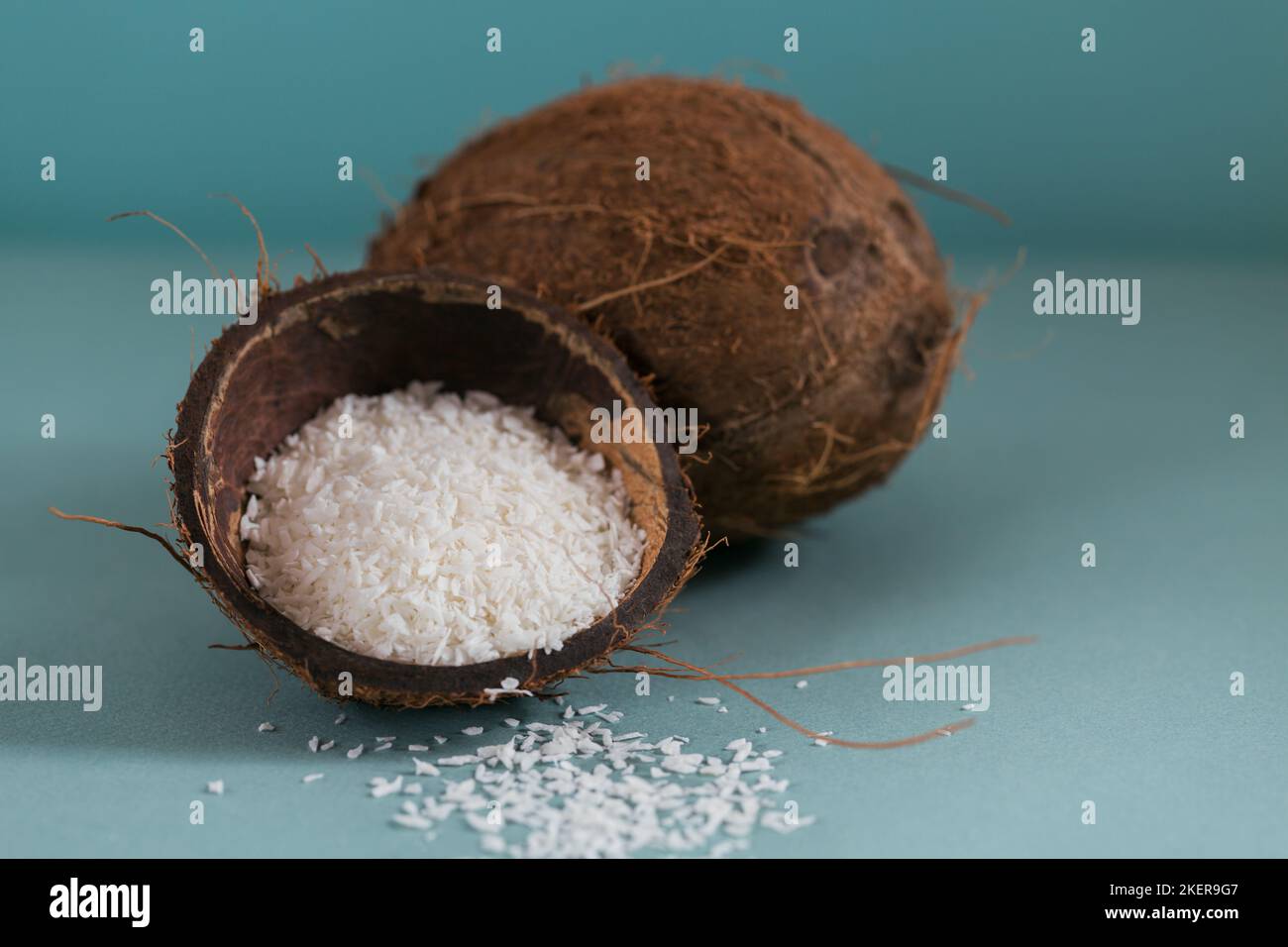 Cocco intero con scaglie di cocco su sfondo blu Foto Stock