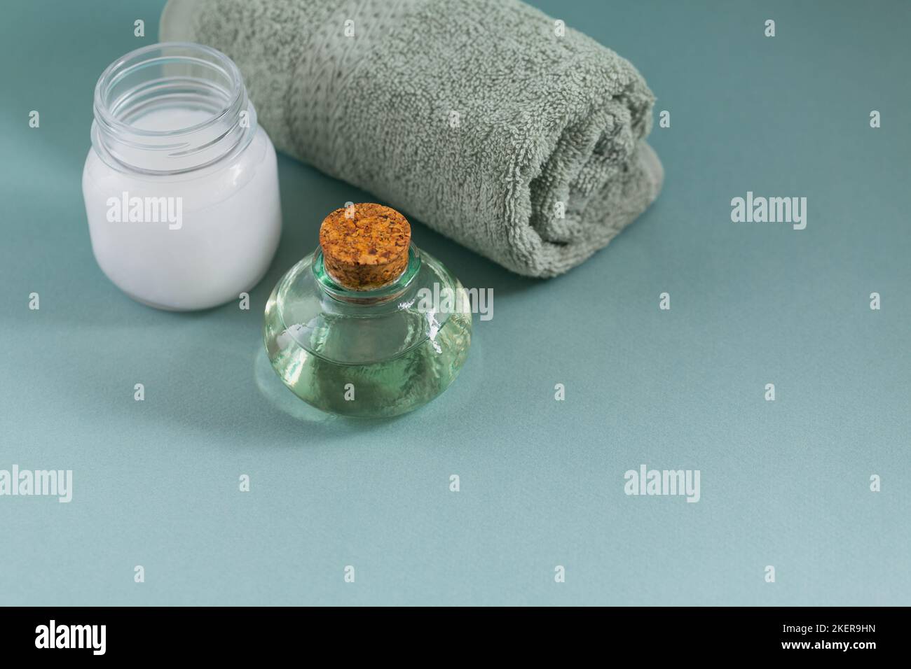 Composizione con olio di cocco naturale organico crema corpo cosmetica su sfondo di colore blu chiaro. Bellezza naturale e concetto di cura del corpo Foto Stock