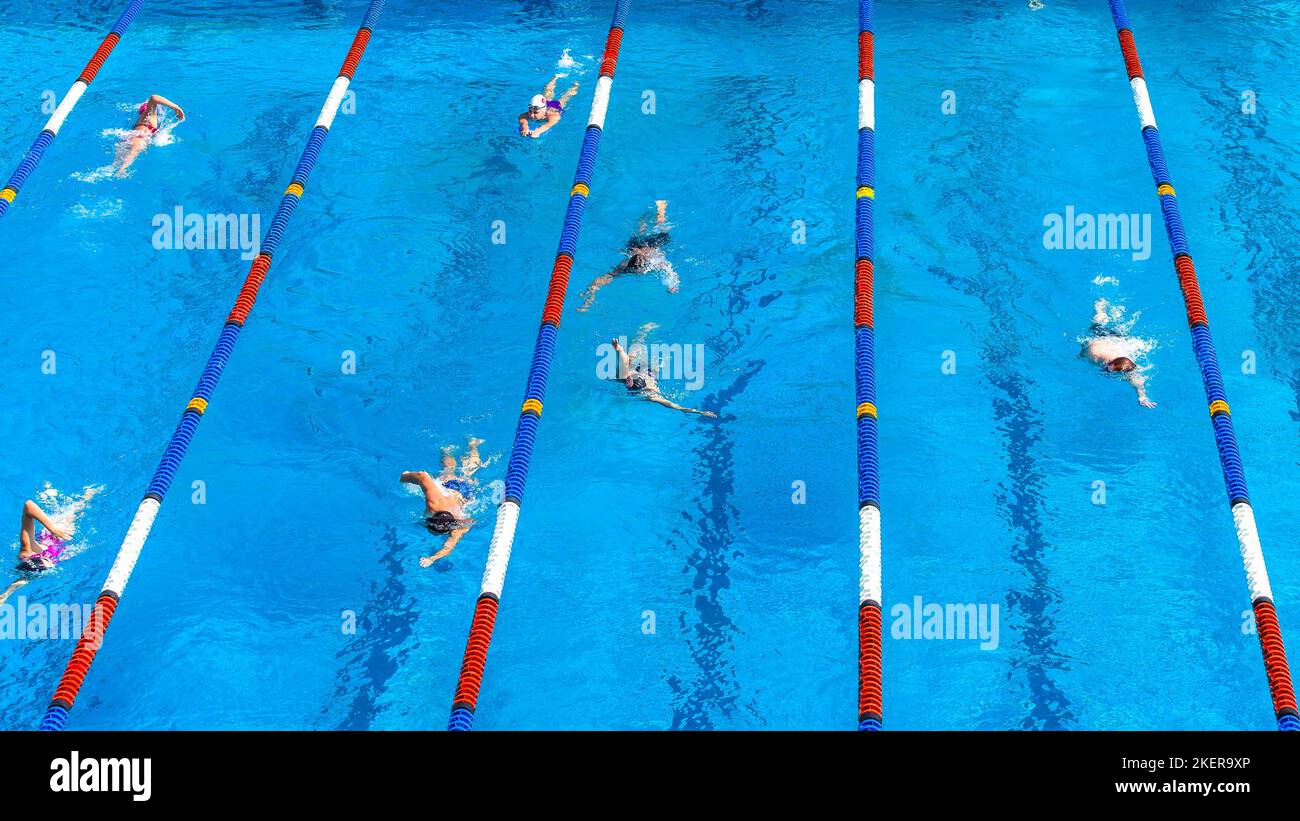 Nuotatori atleti irriconoscibile maschile e femminile esercizio di allenamento in corsie di marcatura foto sopra la piscina all'aperto paesaggio. Foto Stock